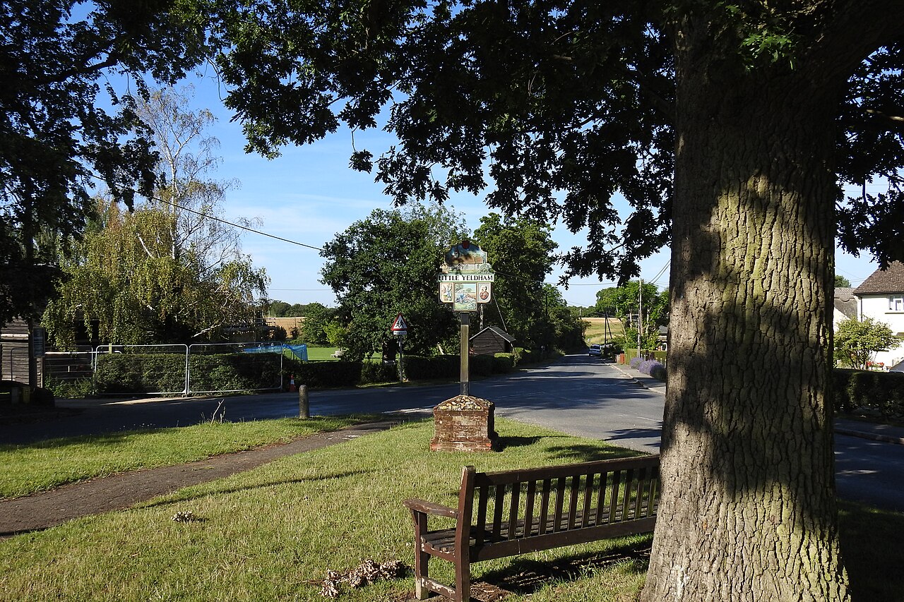Seat and village sign opposite Little Yeldham church
